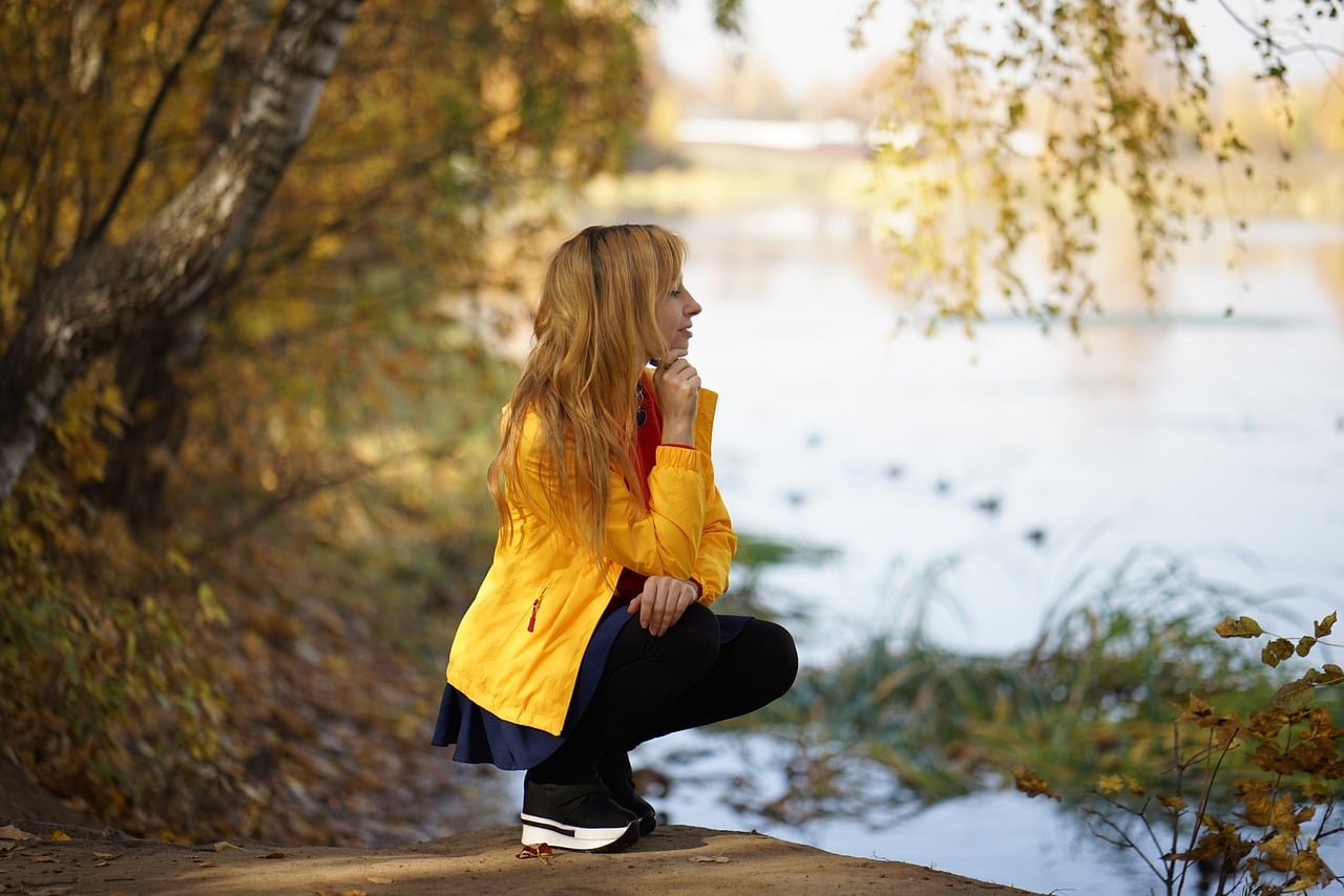 Woman kneeling by a pond