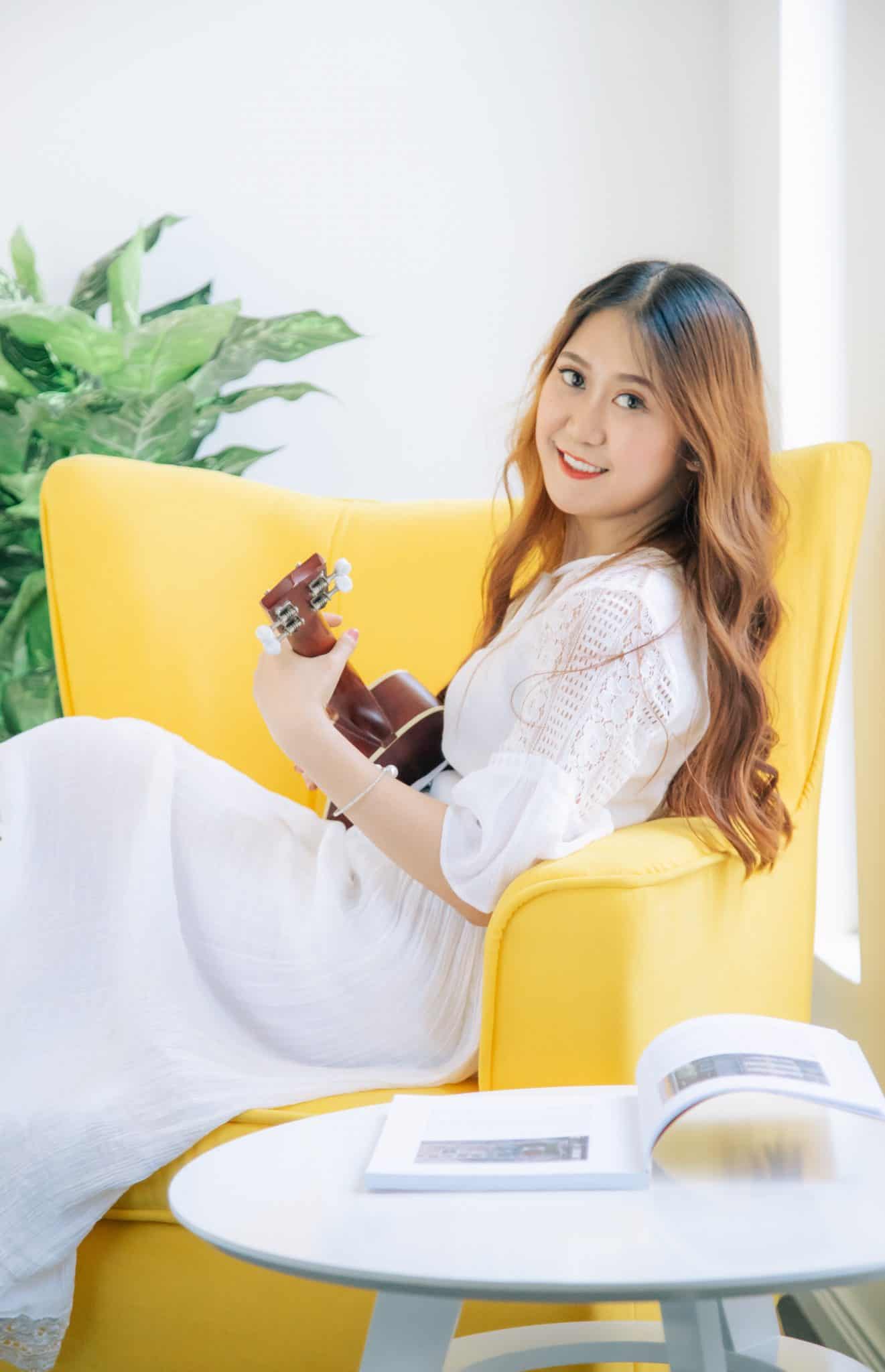 Woman sitting on a chair with a Ukulele